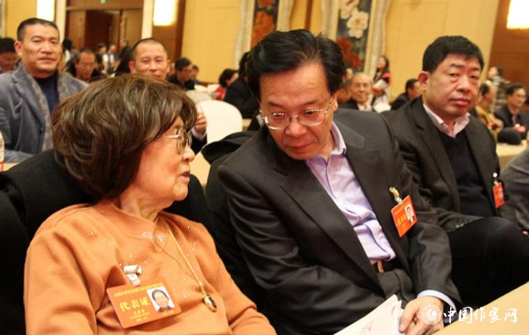 文潔若、李福明等代表在報告會前交談。