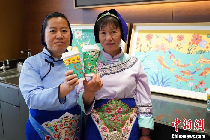 圖為農民畫家展示她們被印在星巴克咖啡紙杯上的畫作。中新網記者劉冉陽 攝