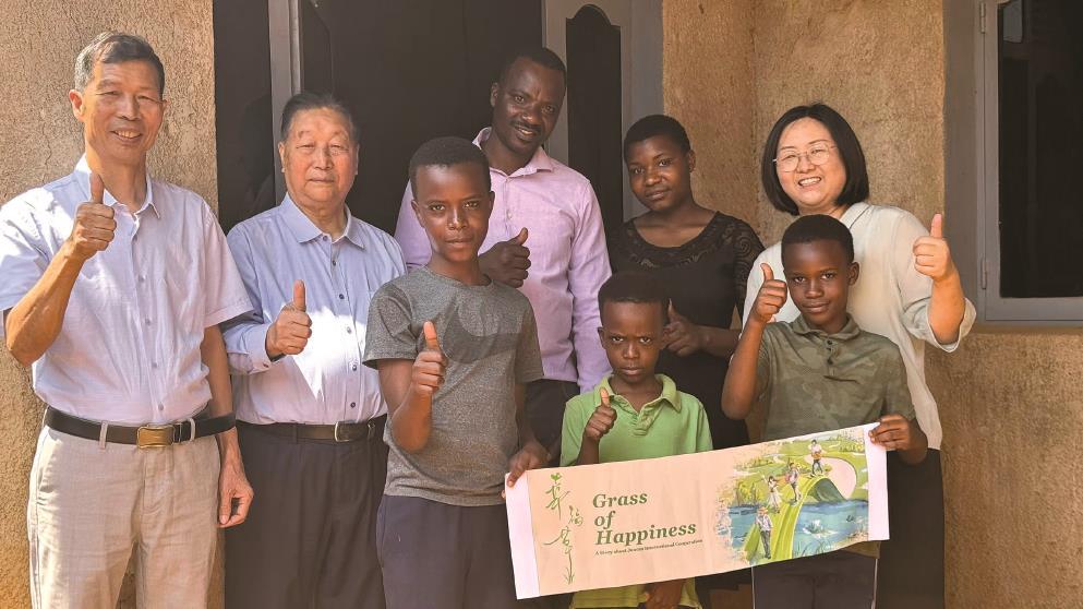 林占熺教授（左二）與盧旺達當(dāng)?shù)匕傩找黄馂橹袊?電視劇《幸福草》“打call”。（受訪者供圖）