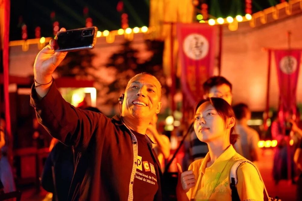 參加2025國際青春詩會的拉美詩人和中國詩人在西安永寧門觀看歡迎儀式。圖為墨西哥詩人馬努艾爾·夸烏特勒在歡迎儀式后與志愿者合影