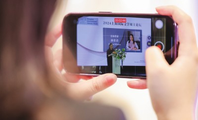 在2024上海國際文學周主論壇的會場，一位觀眾在用手機錄制日本推理小說家湊佳苗的發言。上海國際文學周供圖